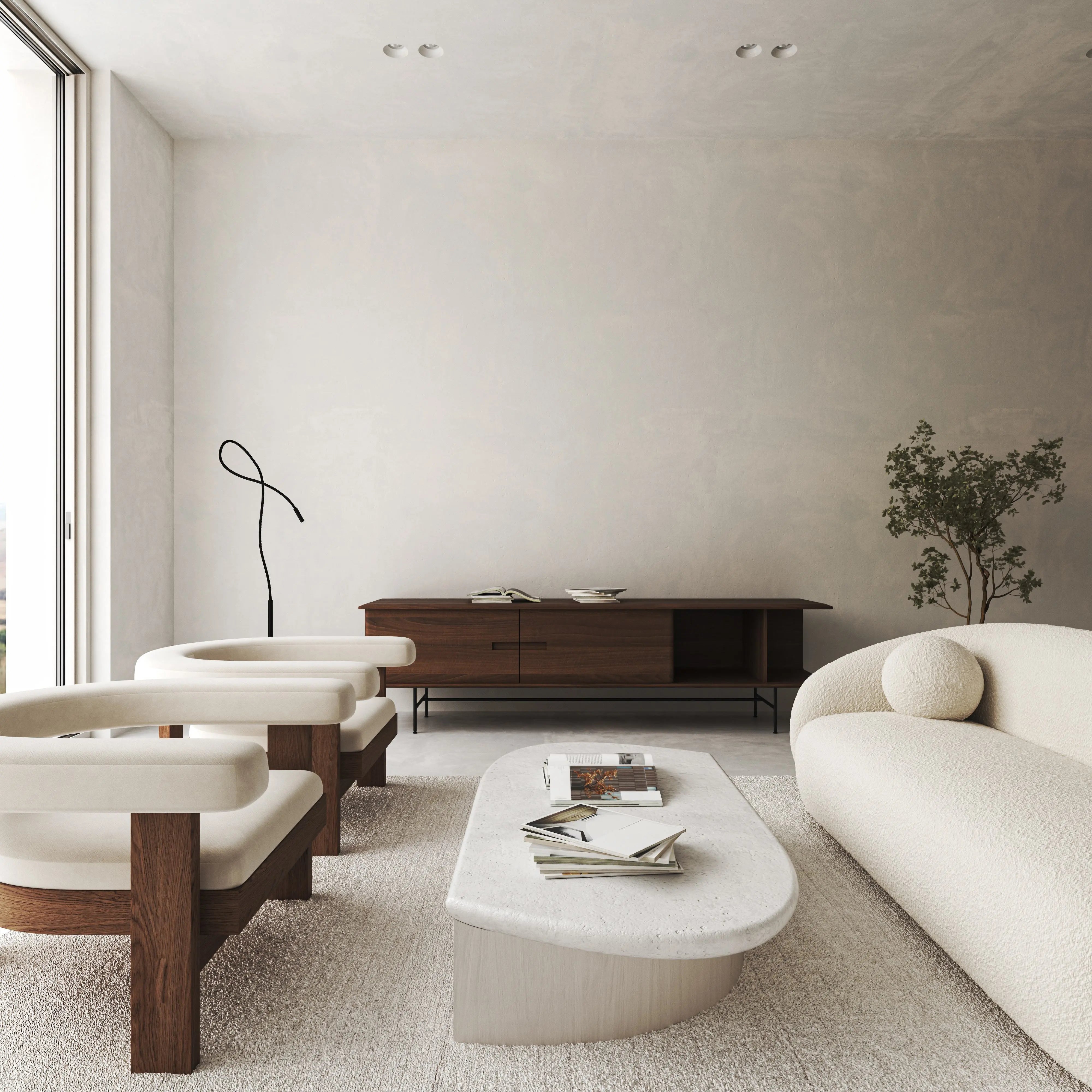 A living room featuring white furniture, a table with magazines, a white couch with a ball, and a tree with leaves.