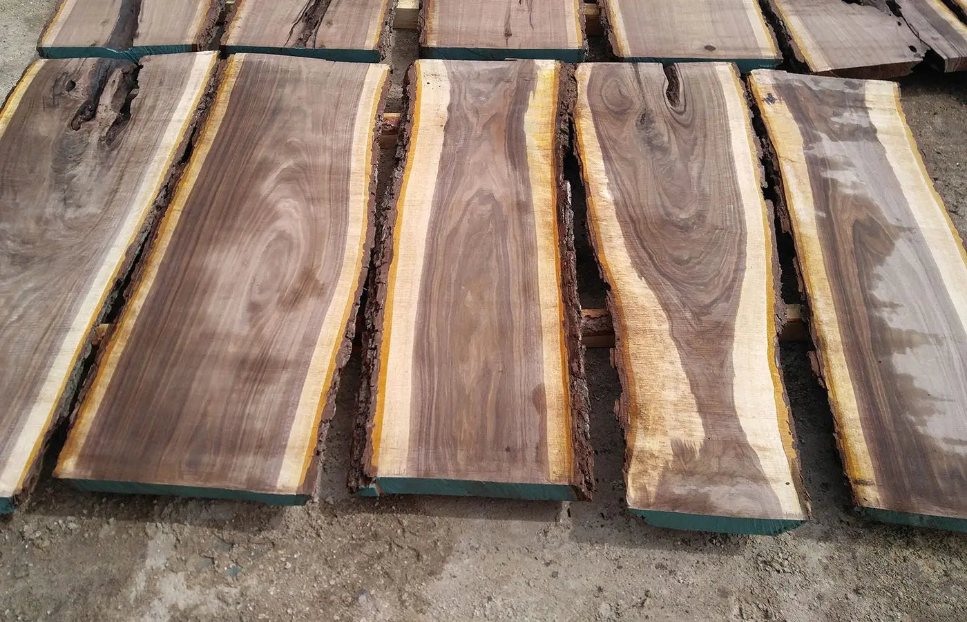 A variety of wooden planks showcasing natural grain patterns and textures, highlighting the raw materials used in carpentry or woodworking projects.