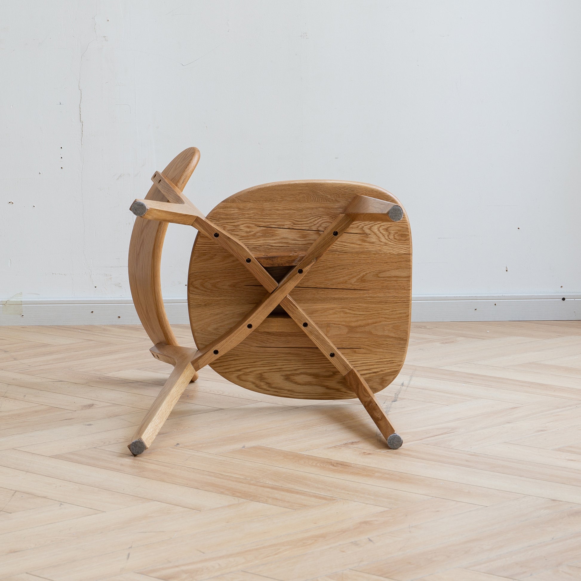 a wooden table with two crossed legs on a hard wood floor