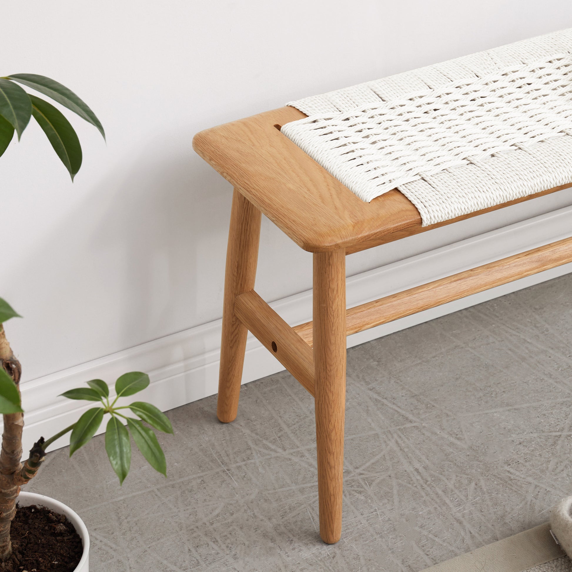 a wooden bench sitting next to a potted plant