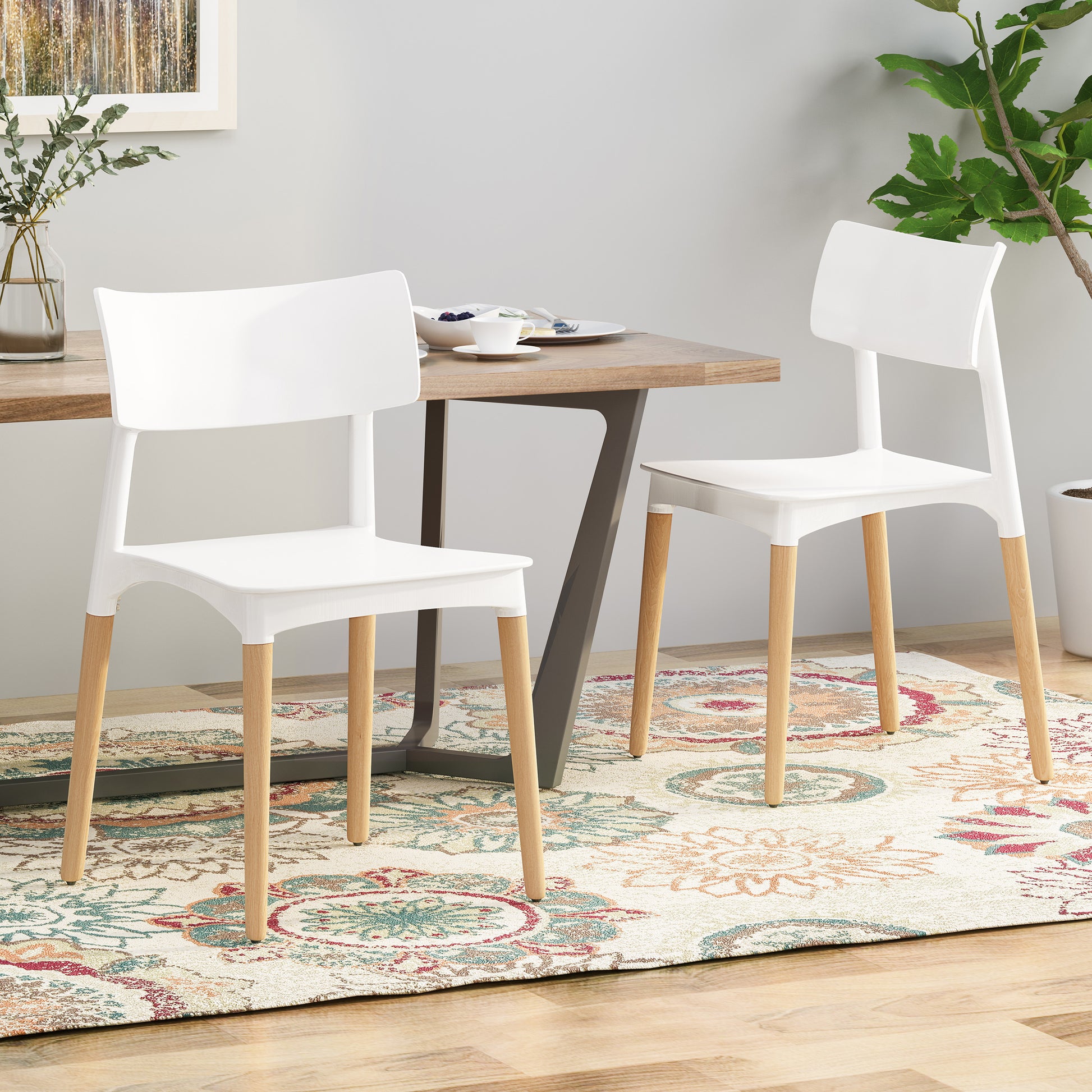 Minimalist White Dining Chair Set with a sleek design, white polypropylene seat, and wooden legs, arranged beside a table, enhancing contemporary dining spaces.