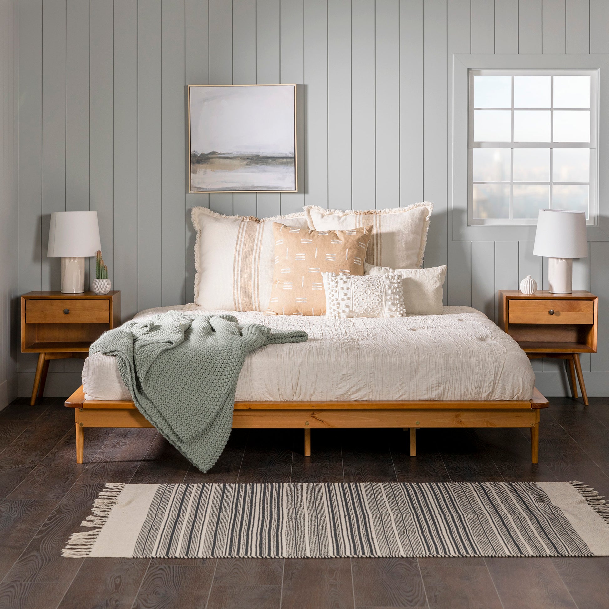 Mid-Century Modern Solid Wood King Platform Bed Frame - Caramel, featuring a sturdy pine structure with tapered legs, displayed with bedding and pillows in a styled room.