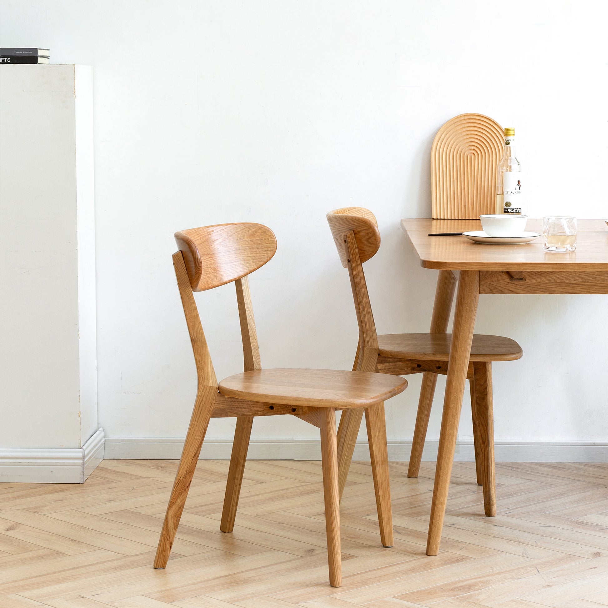 two wooden chairs sitting next to a wooden table