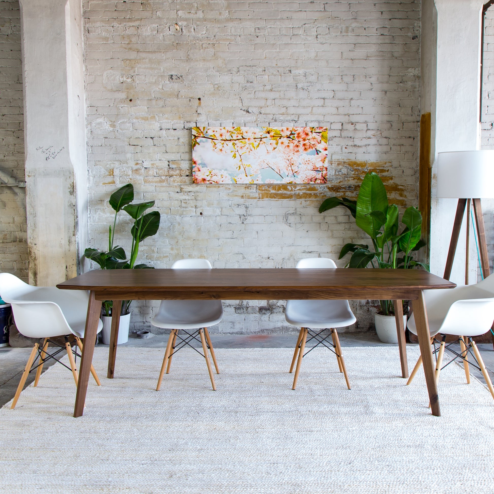 Elevate your dining experience with the Santa Monica, where craftsmanship meets mid-century modern design. (Pictured: A stunning solid walnut dining table with clean lines and tapered legs, embodying timeless elegance.)