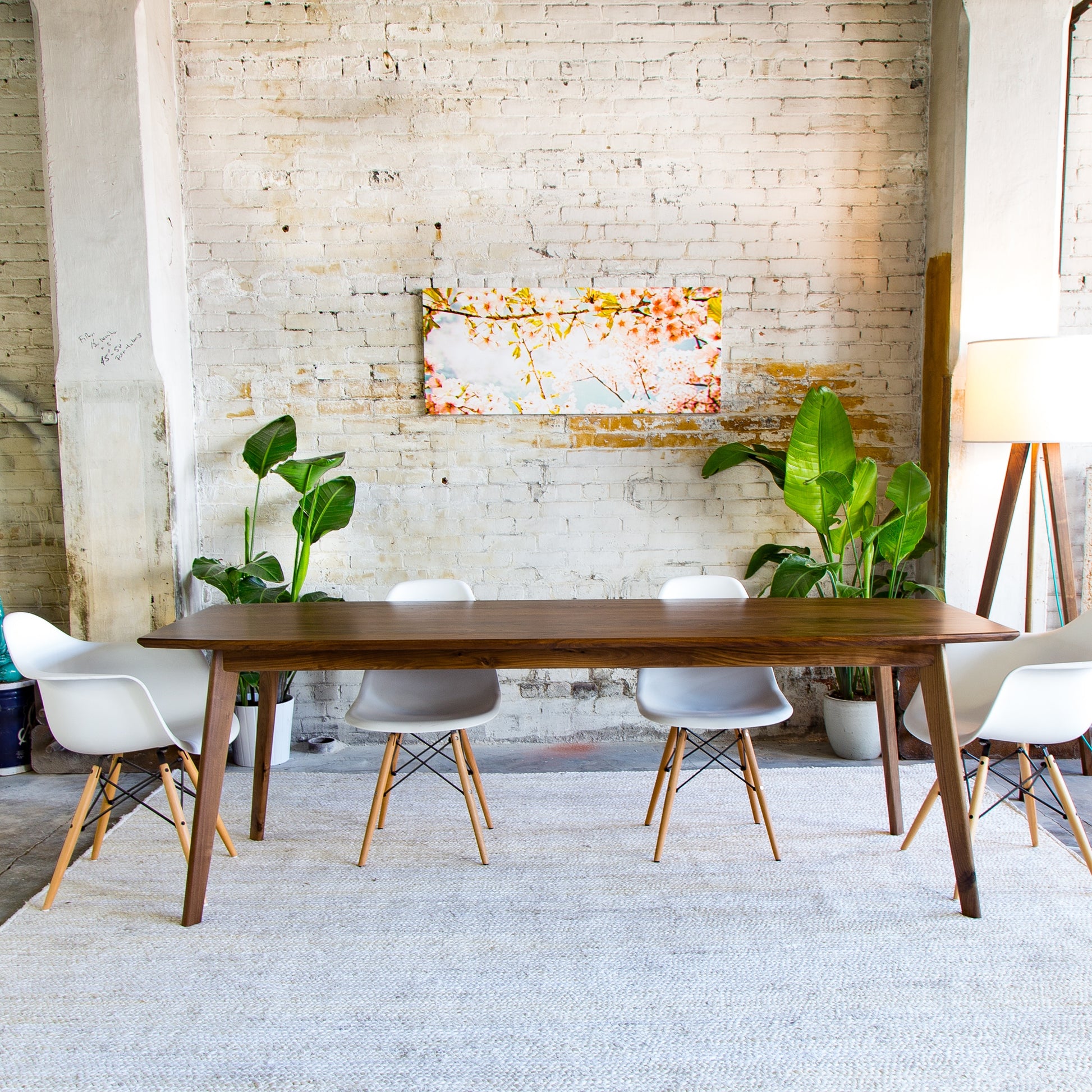 Transform your dining space with the Santa Monica, a testament to mid-century modern artistry. (Pictured: A beautifully designed walnut dining table, featuring a semi-elliptical top and tapered legs.)