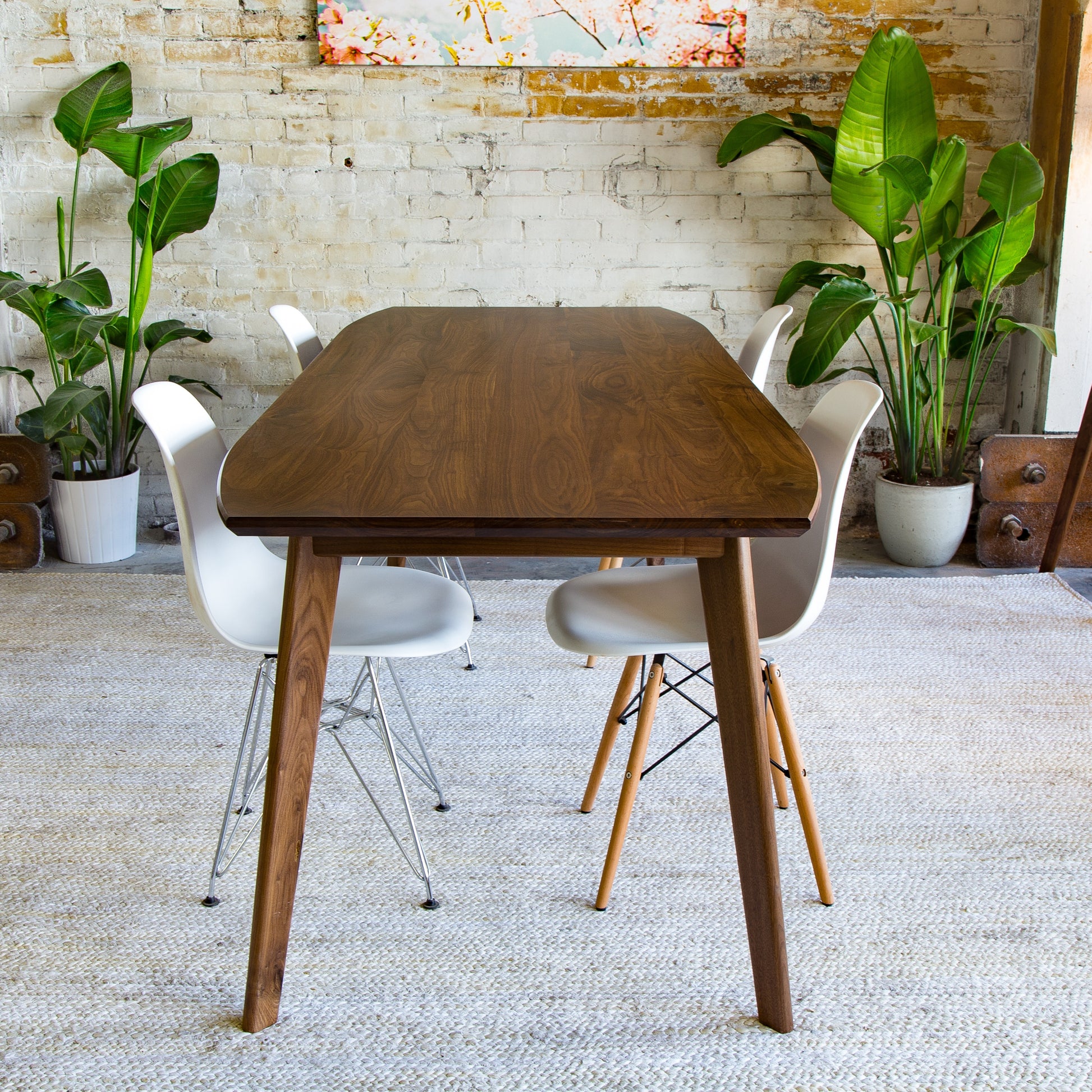 Indulge in the elegance of the Santa Monica dining table, where timeless design meets exceptional craftsmanship. (Pictured: A solid walnut mid-century modern table with clean lines and a sophisticated finish.)