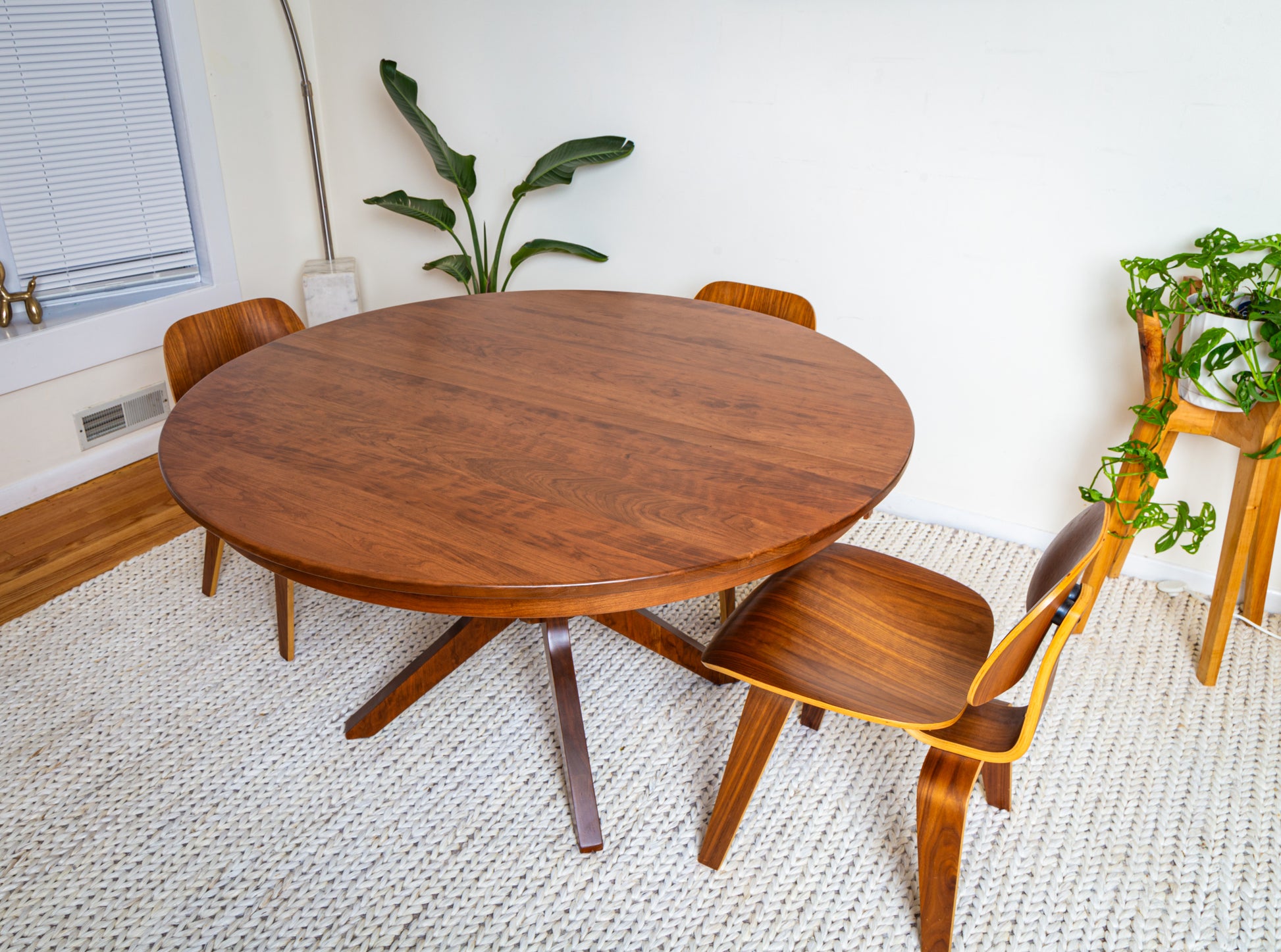 Corcovado: Modern Small Dining Table for 4 to 8, featuring a round wooden design with chairs, showcasing its extendable functionality in a stylish indoor setting.