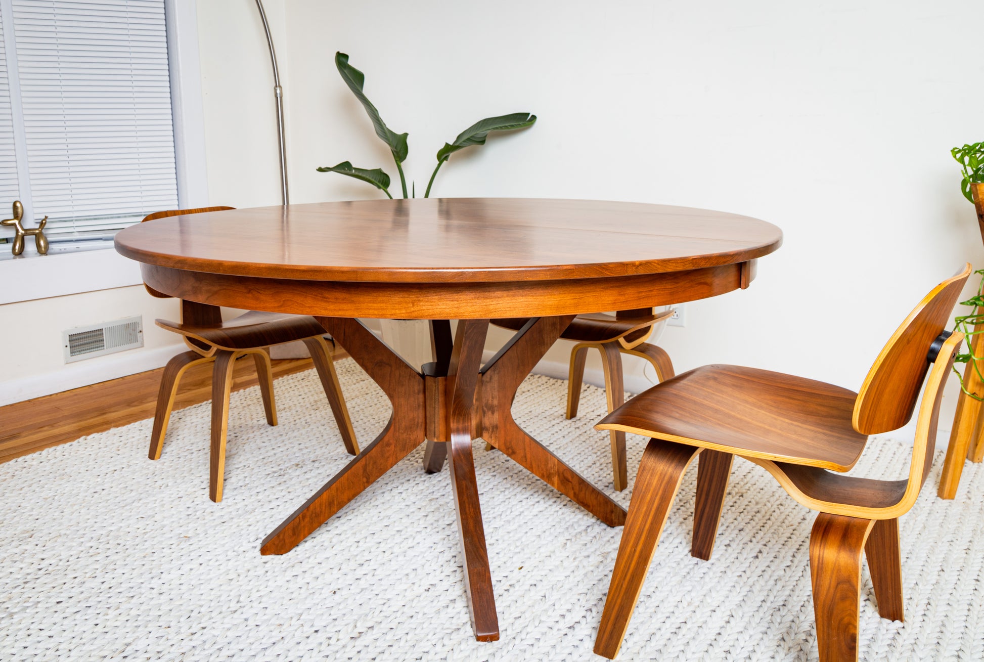 The Corcovado: Modern Small Dining Table for 4 to 8, Extendable, shown with chairs in a dining room setting, featuring solid hardwood craftsmanship.