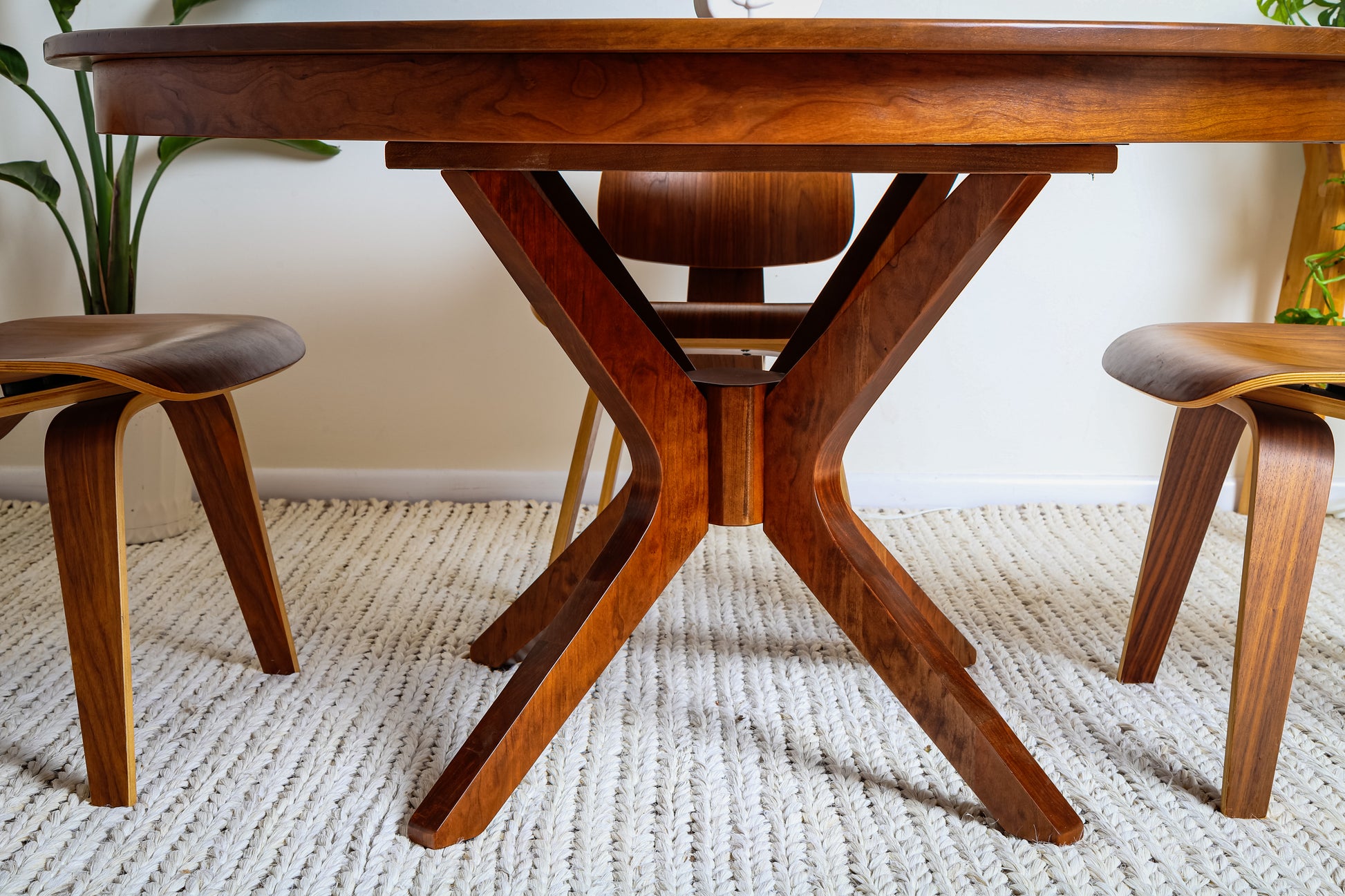 The Corcovado: Modern Small Dining Table for 4 to 8, Extendable, crafted from solid hardwood, features a round top and wooden legs on a rug.