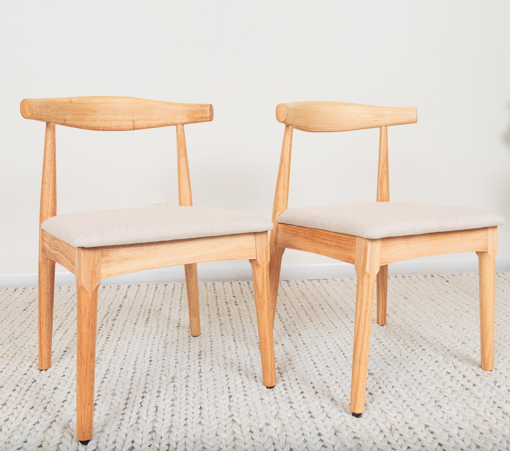 Mid-Century Modern Dining Chair set of two, featuring Ox Chair-inspired design with curved backrest and cushions on a rug. Crafted from durable parawood.