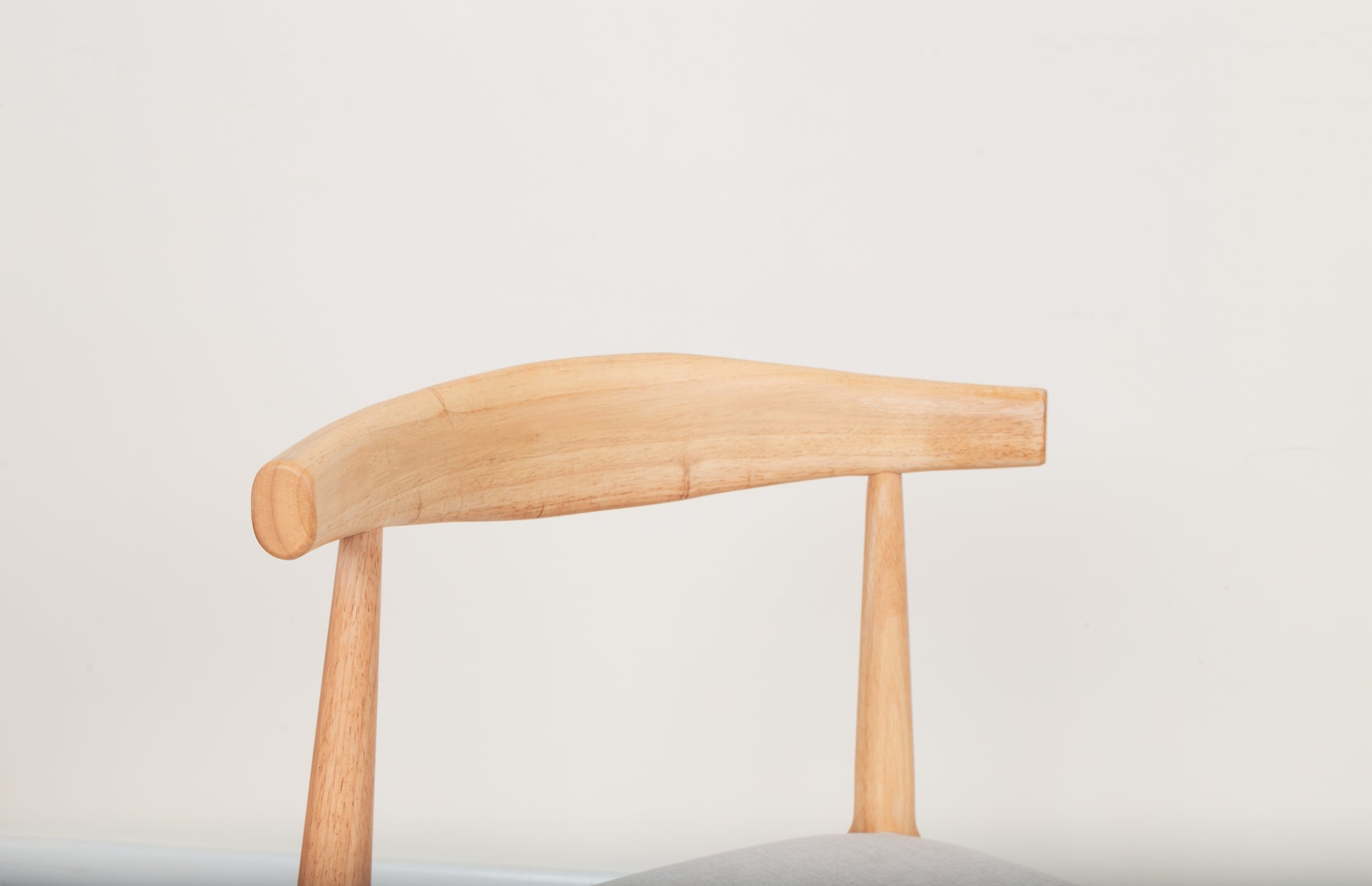 Mid-Century Modern Dining Chair with curved wooden backrest and armrests, inspired by the Ox Chair, crafted from durable parawood for ergonomic dining comfort.