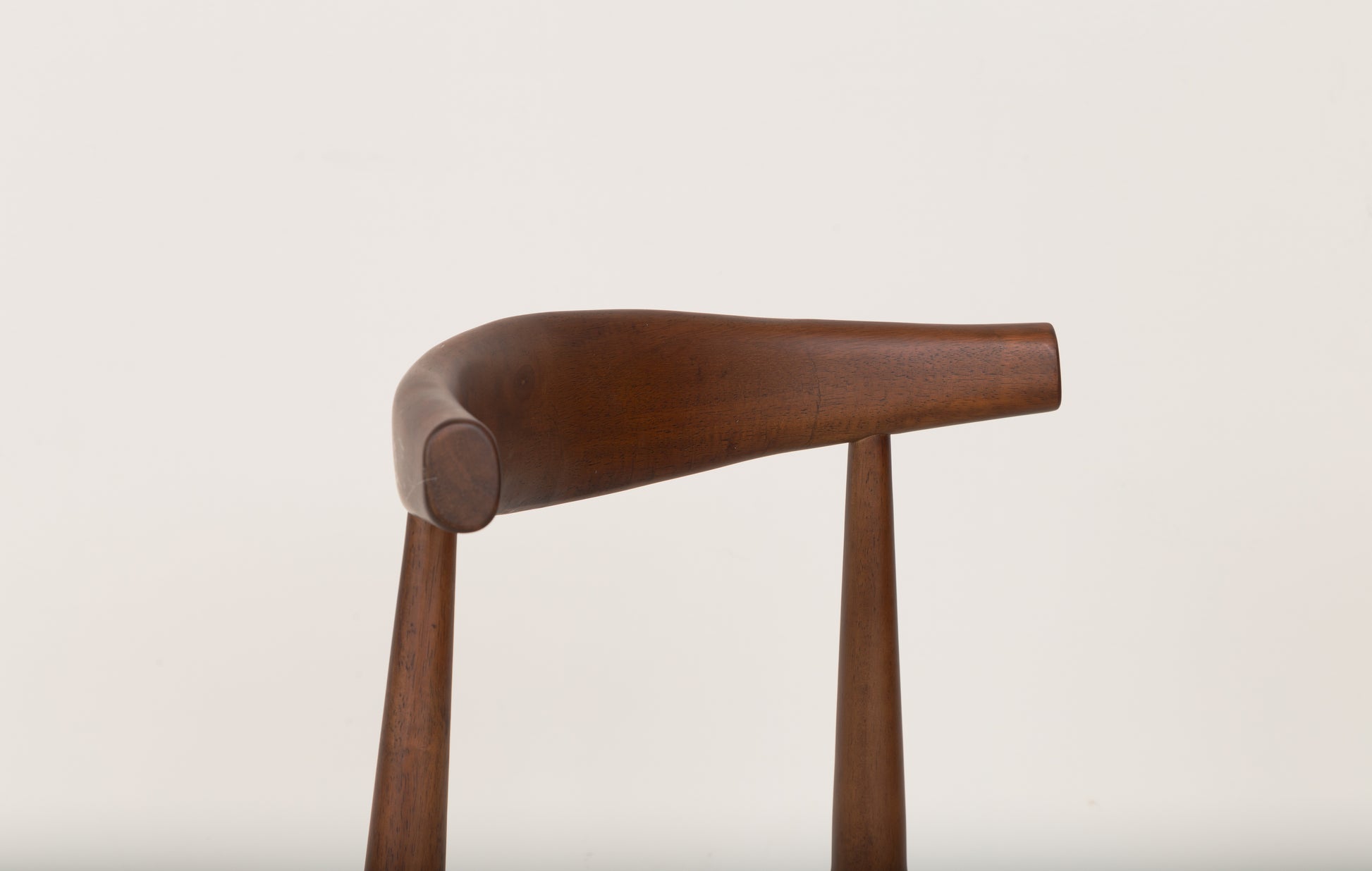 Mid-Century Modern Dining Chair: Wooden chair with curved arm, inspired by the Ox Chair design, crafted from solid parawood for ergonomic support and style.