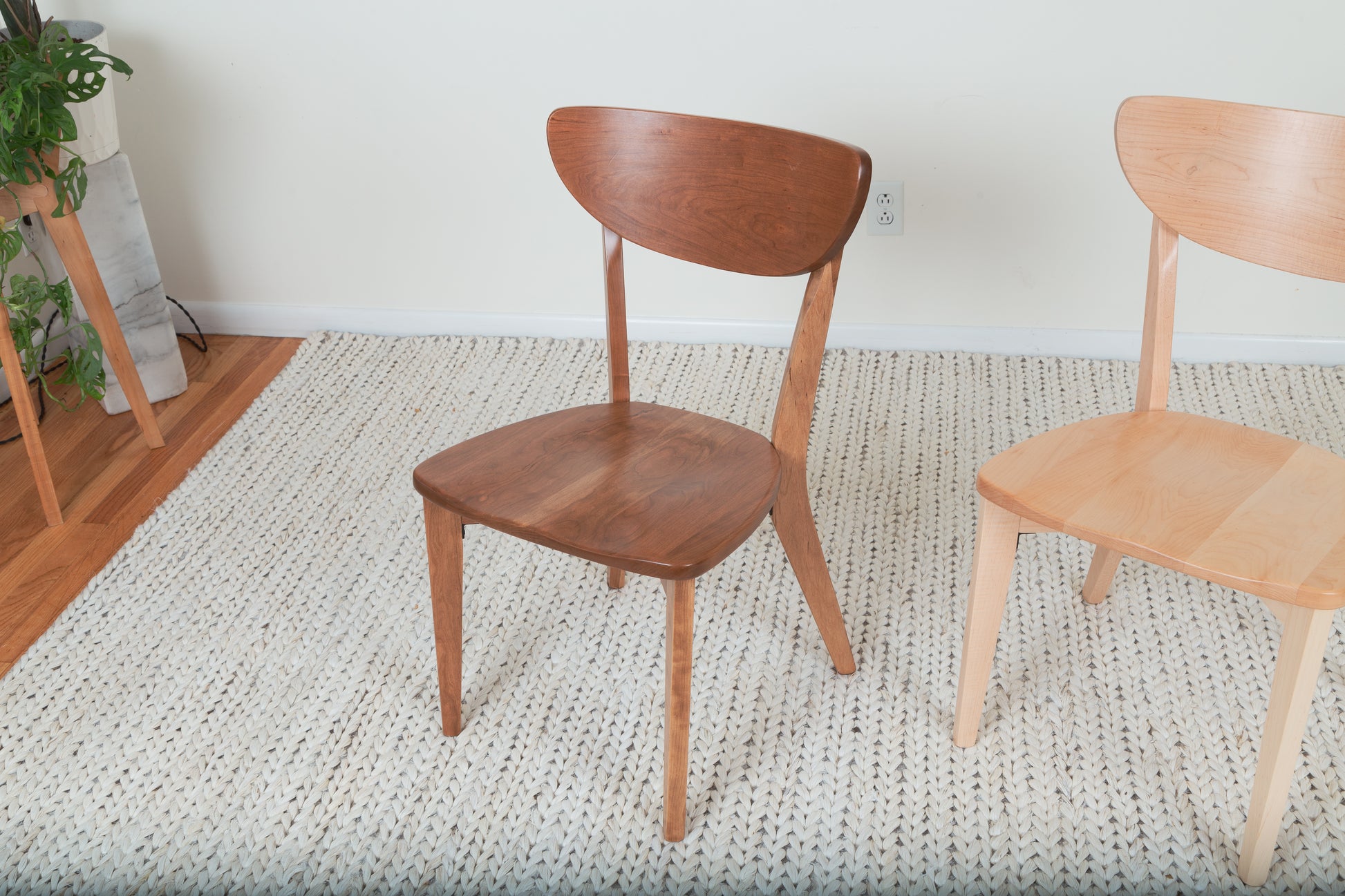 The Seymour - Modern Dining Chair, a solid wood chair on a rug, showcases sleek design and ergonomic comfort, perfect for enhancing dining spaces.