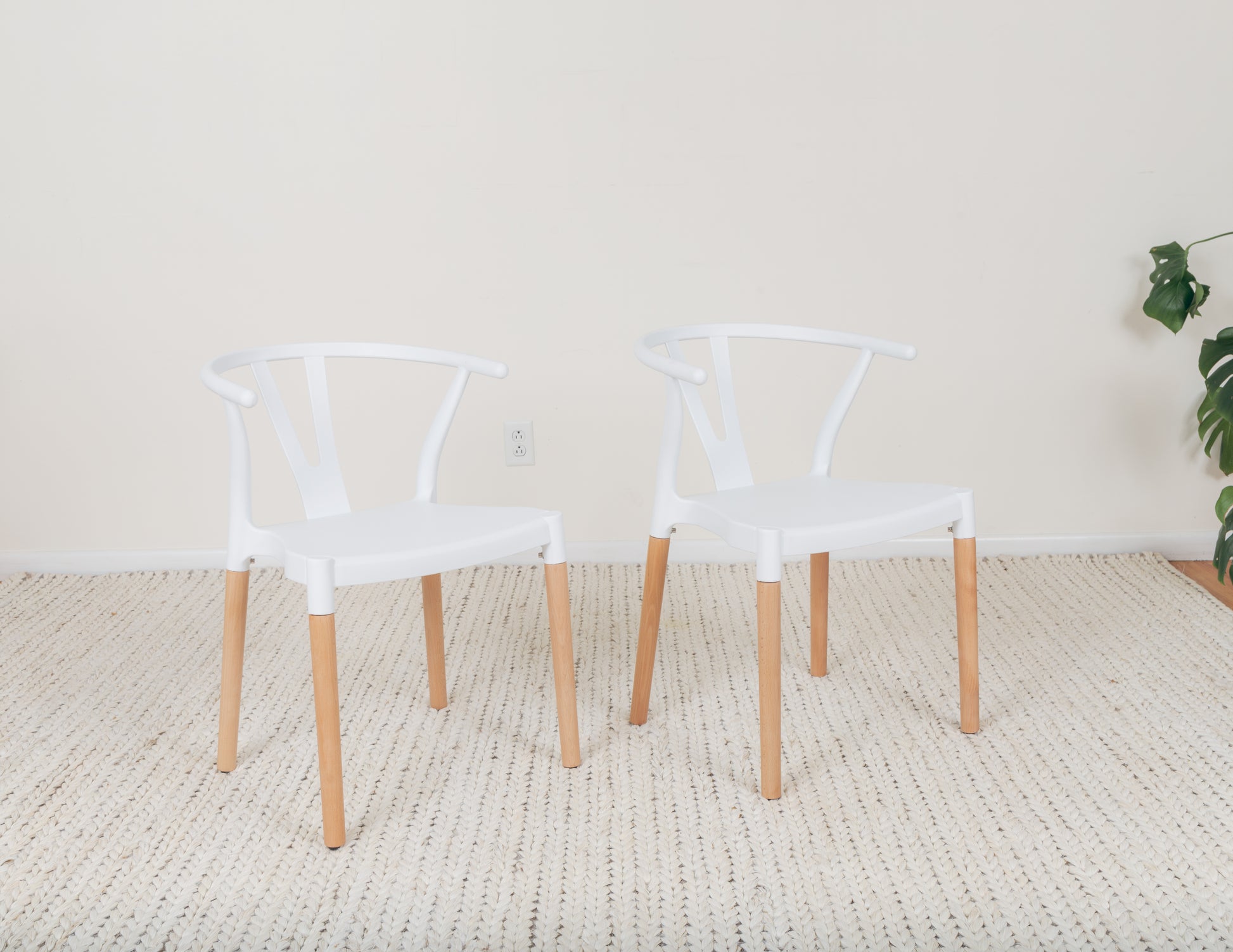 a pair of white chairs sitting on top of a rug