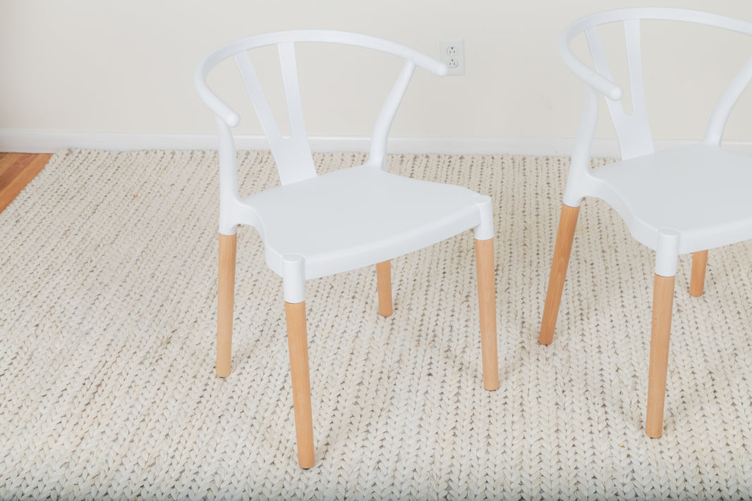 a pair of white chairs sitting on top of a rug