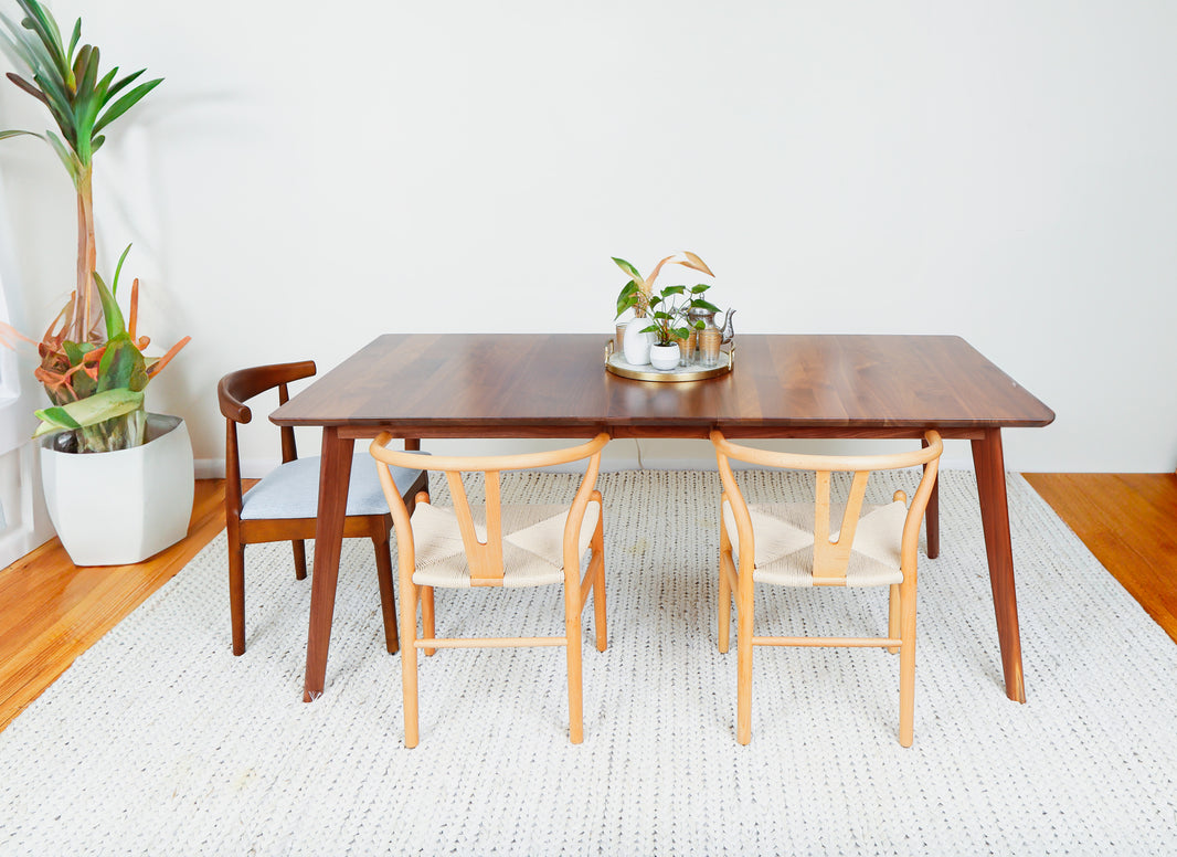 a table with two chairs and a potted plant