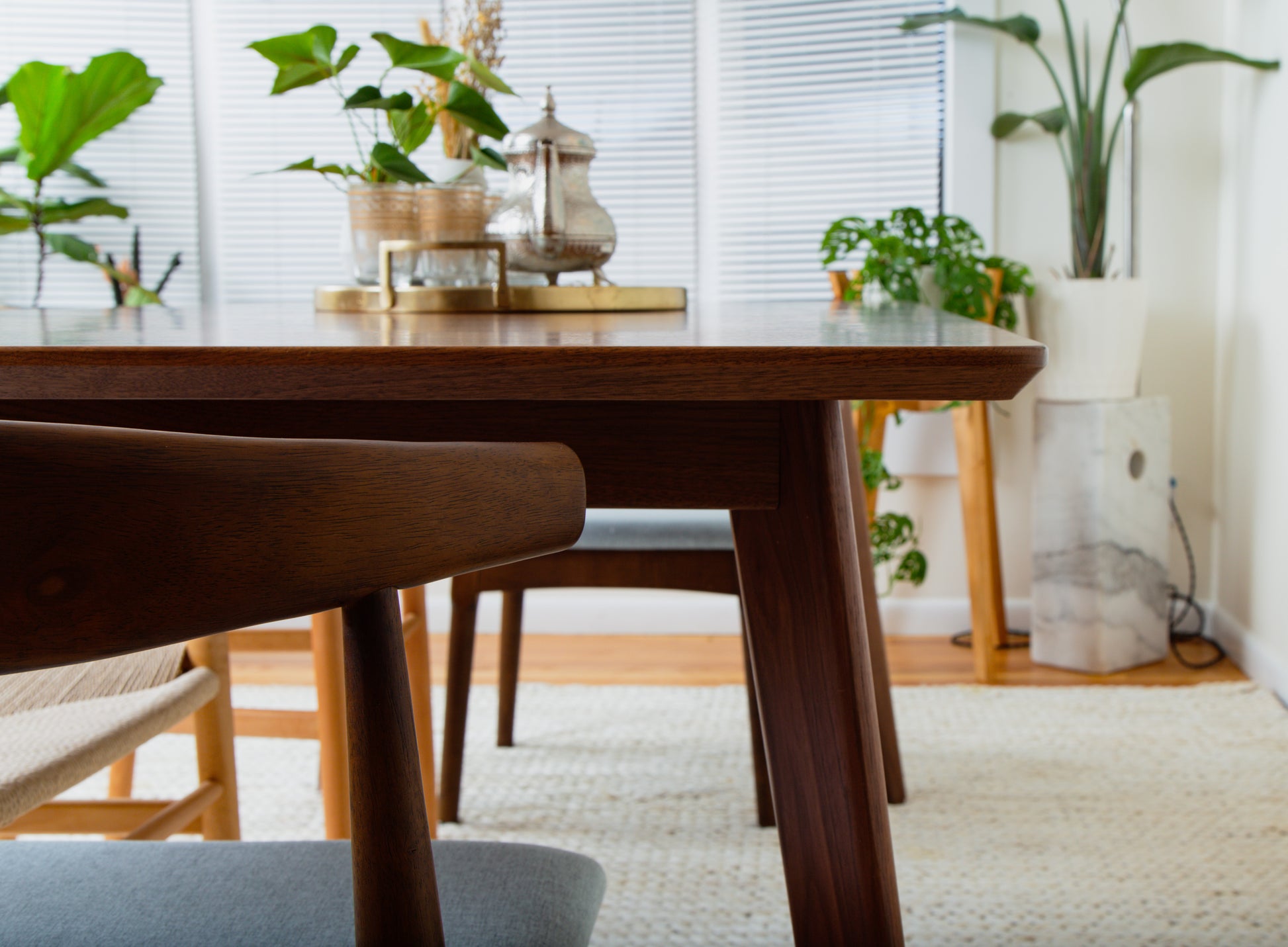 a wooden table with chairs and plants on it