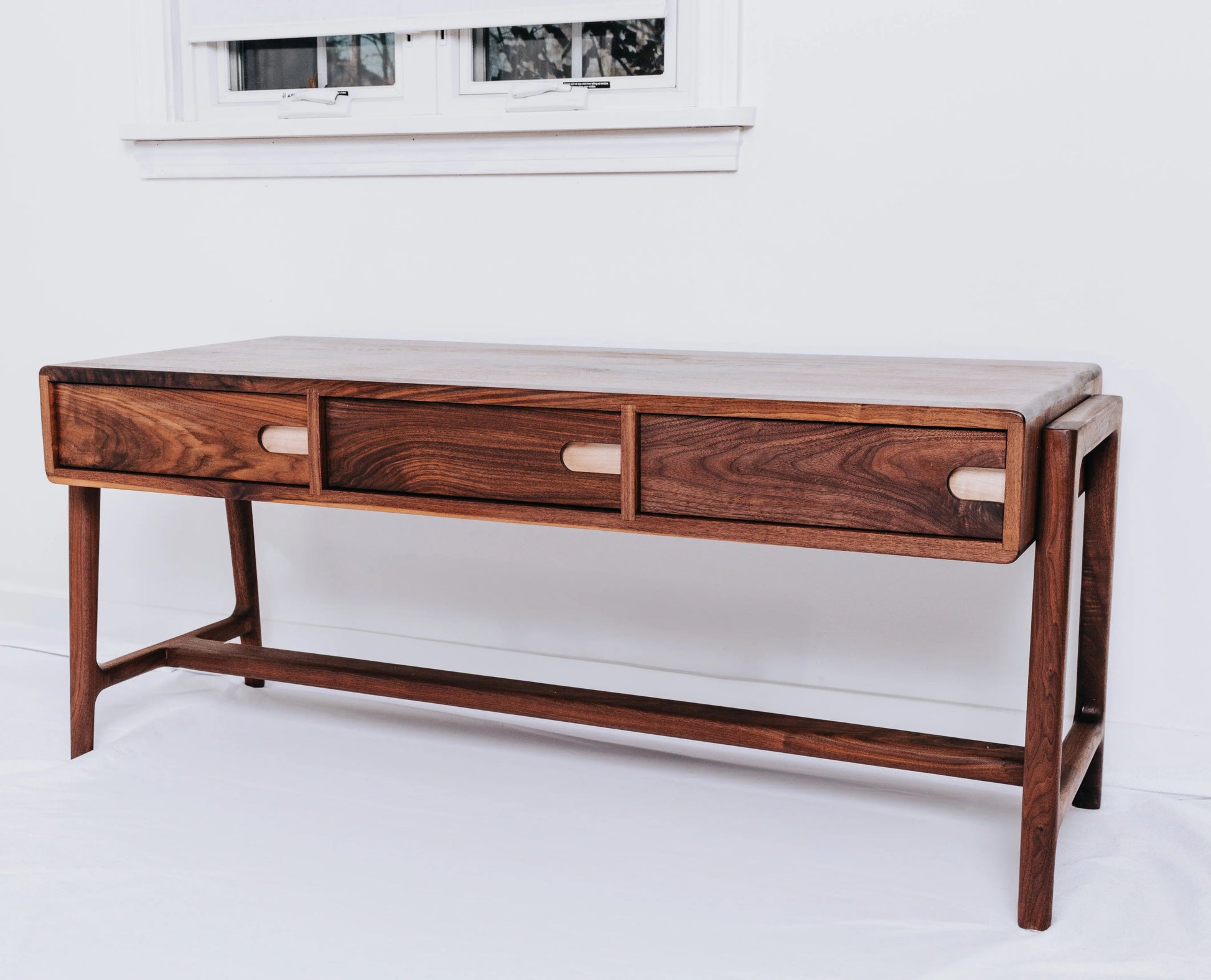 Luxury black walnut coffee table with rock maple features, embodying Nordic design and Ohio craftsmanship.