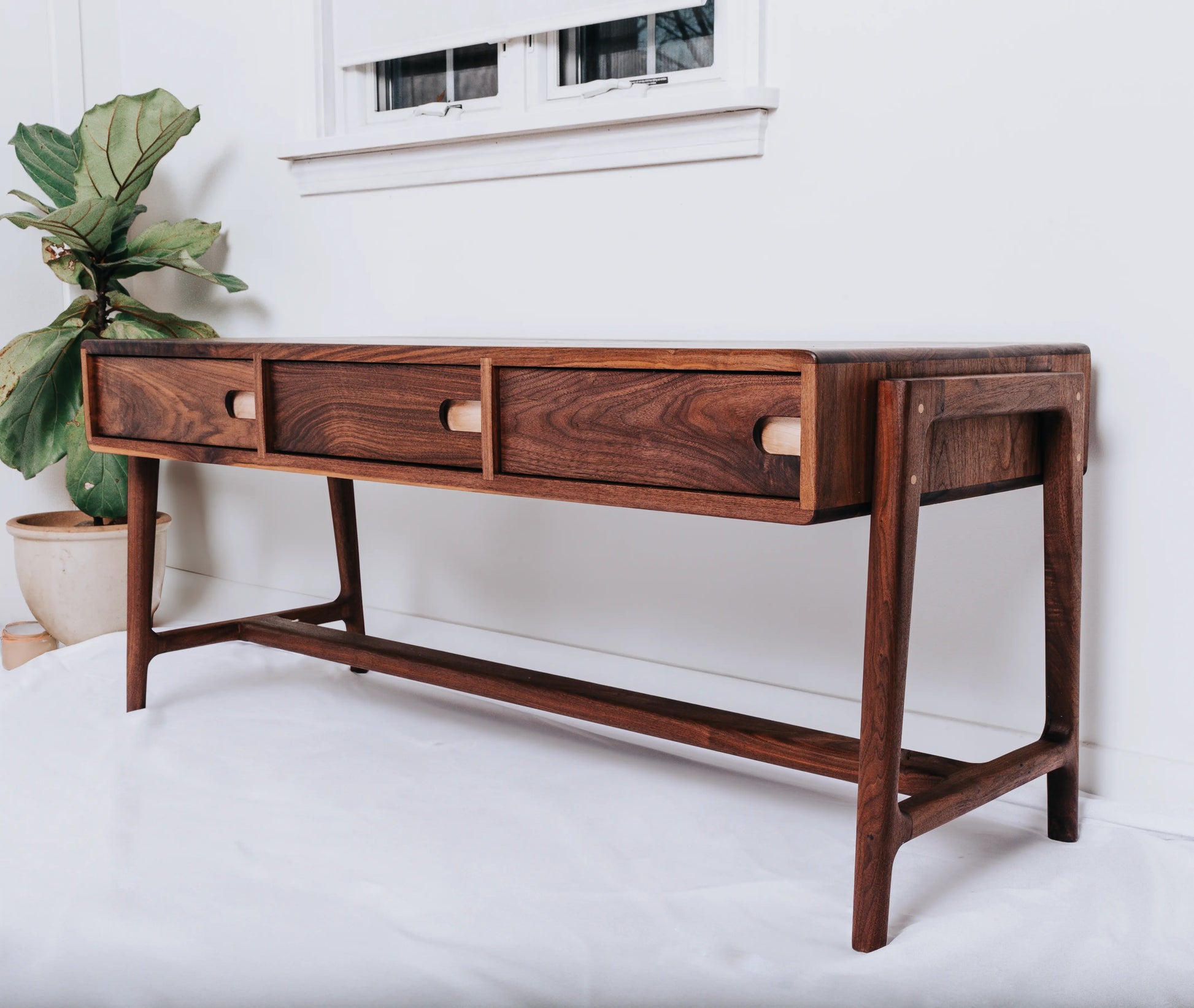 Elegant black walnut coffee table with rock maple accents and soft-close drawers in a Scandinavian design