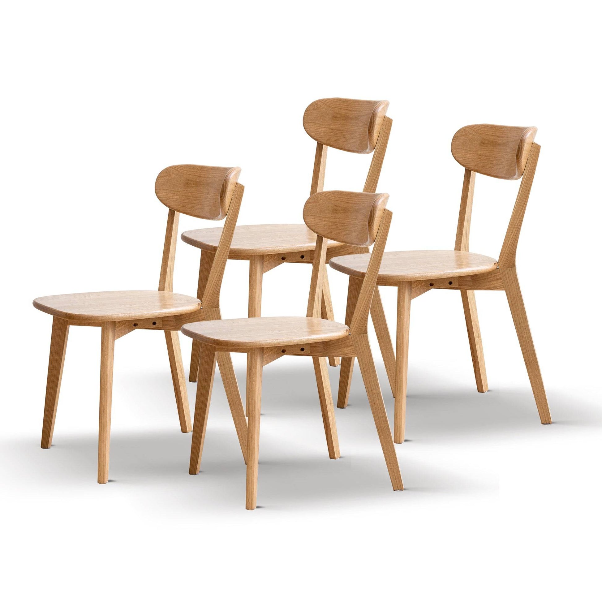 a set of four wooden chairs sitting next to each other