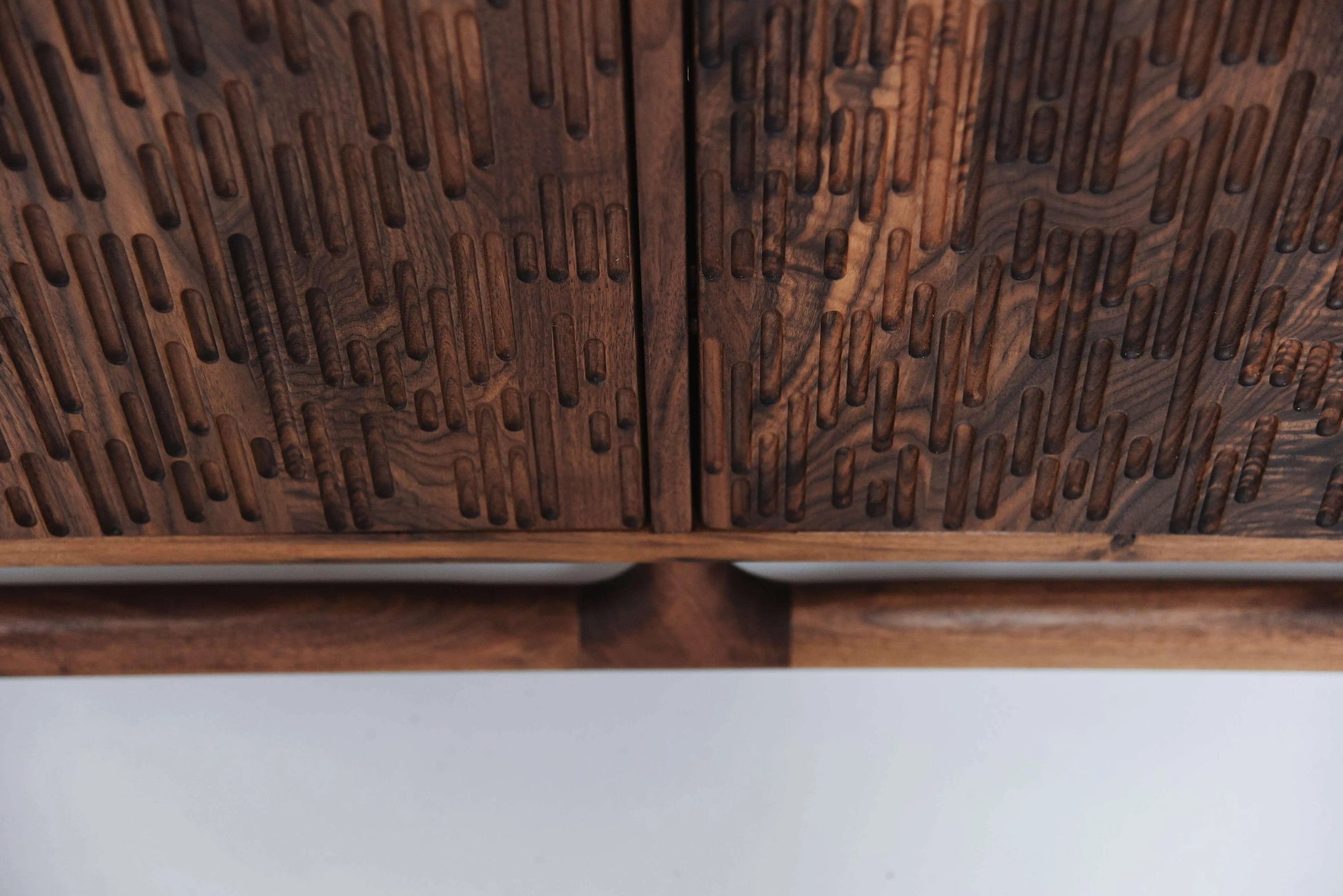 Detail of cnc textured credenza doors in walnut