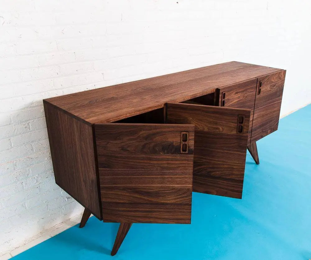 A Walnut Mid Century Modern Credenza, Blue floor with White Background. Side View with doors open.
